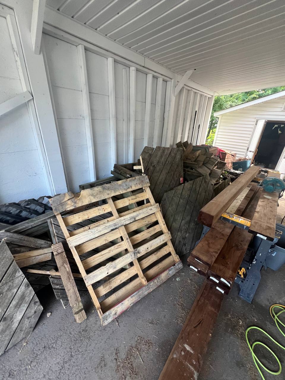 Before: stacked pallets, old lumber and debris piled along the side of a Moncton home